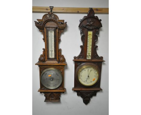 TWO EARLY 20TH CENTURY OAK/MAHOGANY ANEROID BAROMETERS, both with thermometers with one that has a spiralling base, signed by