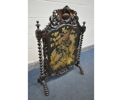 A VICTORIAN CARVED OAK FIRESCREEN, the detailed foliate decorated frame, central lettering reading ACM, barley twist uprights