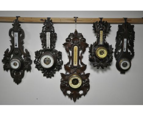 FIVE VARIOUS LATE 19TH/EARLY 20TH CENTURY CARVED WOOD ANEROID BAROMETERS, all unsigned, largest barometer height 66cm (5) (co