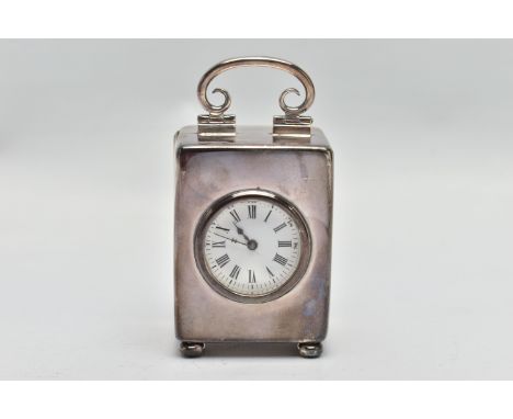 AN EDWARDIAN WILLIAM COMYNS MINIATURE SILVER BOUDOIR CLOCK, the plain case with swing carrying handle, enamel dial with Roman