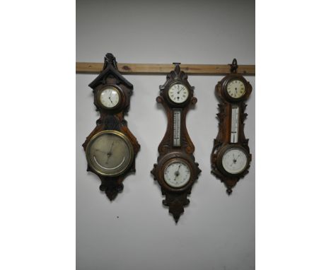 THREE LATE 19TH/EARLY 20TH CENTURY CARVED WOOD BAROMETERS, with clock dials, and two with thermometers, one unsigned, one sin
