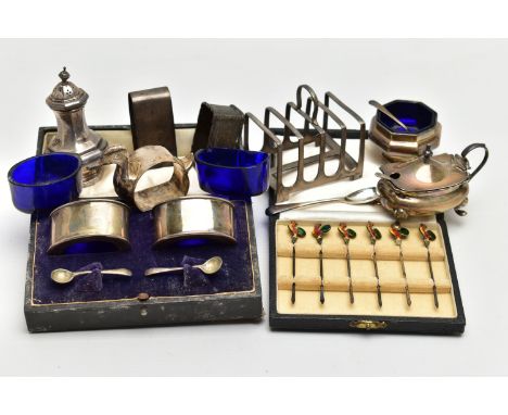 A PARCEL OF SILVER CRUET ITEMS, NAPKIN RINGS, TOAST RACK, ETC, including a cased set of six cocktail sticks with enamelled co