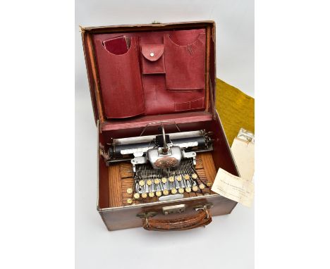 AN EARLY 20TH CENTURY BLICK ALUMINIUM FEATHERWEIGHT TYPEWRITER IN A TAN LEATHER COVERED CASE, the red fabric lined case inter