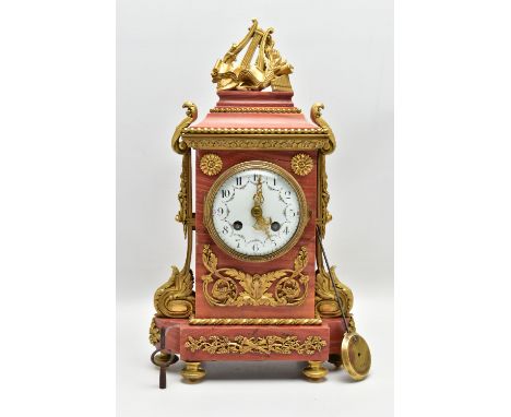 A MID 19TH CENTURY FRENCH RED MARBLE AND ORMOLU MANTEL CLOCK, the stepped rectangular top with musical motifs surmount above 