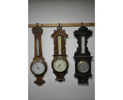 THREE LATE 19TH/EARLY 20TH CENTURY CARVED WOOD ANEROID BAROMETERS, all with thermometers and unsigned, max height 90cm (3) (c