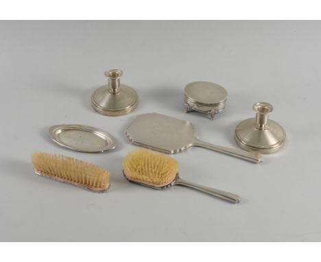 A SILVER MOUNTED SEVEN PIECE DRESSING SETComprising; a pair of candlesticks, Birmingham 1958, a hand mirror, Birmingham 1957,