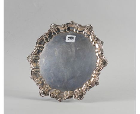 A SILVER SHAPED CIRCULAR SALVERDecorated with a Chippendale style pie-crust rim, with scallop motifs at intervals, raised on 