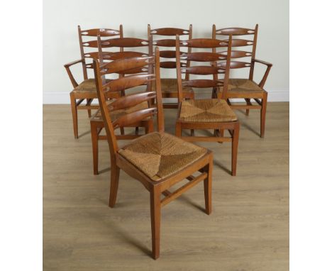 A SET OF SIX MID 20TH CENTURY OAK AND YEW WOOD PIERCED LADDER BACK DINING CHAIRS (6)With rush seats, to include two carvers, 