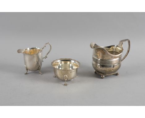 A SILVER MILK JUG AND MATCHING SUGAR BOWL AND ANOTHER SILVER MILK JUG (3)The first two pieces, each raised on three feet and 