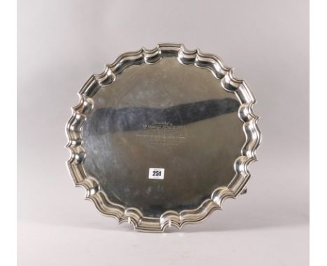A SILVER SALVEROf shaped circular form, having a pie-crust rim in the Chippendale style, raised on three scrolled feet, prese