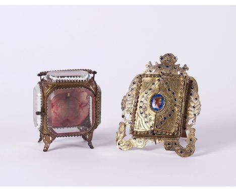 AN AUSTRIAN GILT-METAL AND ENAMEL FRAME AND A POCKET-WATCH STAND (2)Late 19th Century and Early 20th Century
The shield-shape