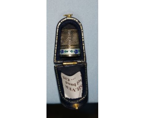 A cased silver thimble with enamel band 