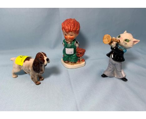 A Goebel Hummel cat playing the trumpet; A Goebel Hummel figure of a boy and dog; a Beswick figure of a spaniel 