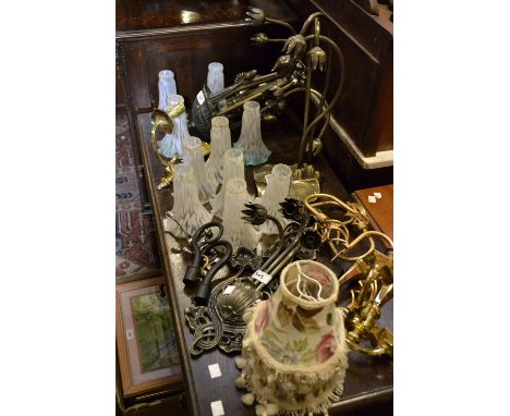 Light fittings in the Art nouveau style to include a five arm central ceiling light; a wall light and table lamp; three brass