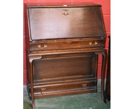 A Globe Wernike style bureau, fall front enclosing pigeonholes, sabre supports, book case and drawer to base. 112cm high x 86