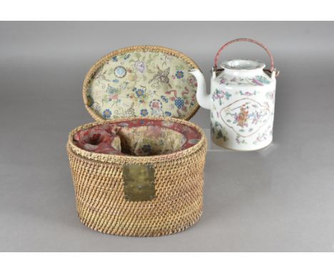 A 19th Century Chinese famille rose teapot, within a wicker basket with silk embroidered cushioned lining, missing cup, baske