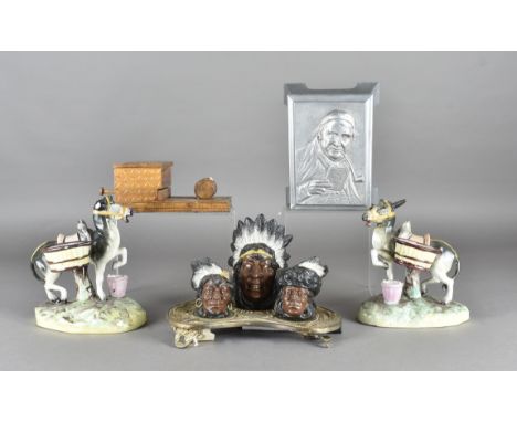 A painted and gilt metal smoker’s companion in the form of three Indian heads on a shaped and cast base, an aluminium musical