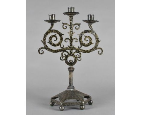 An Art Deco wrought iron Continental three branch candelabra, of scroll design, 43 cm x 29 cm 