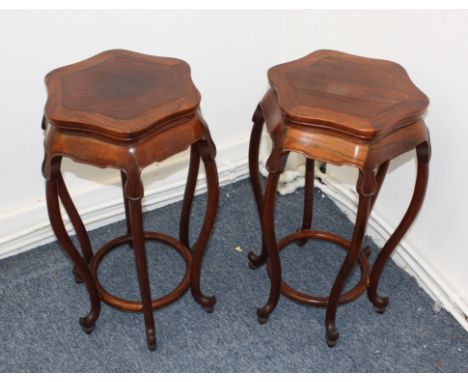 A pair of 19th Century Chinese hardwood stands, the hexagonal tops supported by eight shaped legs with scroll ends, 58 cm hig