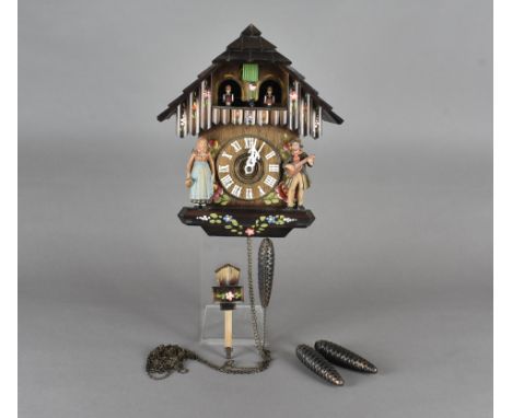A 20th Century Black Forest cuckoo wall clock the case in the form of a cabin, with a Swiss musical movement, the case 32 cm 