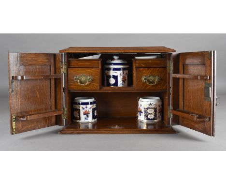 A 19th Century carved oak pipe cabinet, the rectangular shape, with carved panel doors, hinged moulded top, fitted interior w