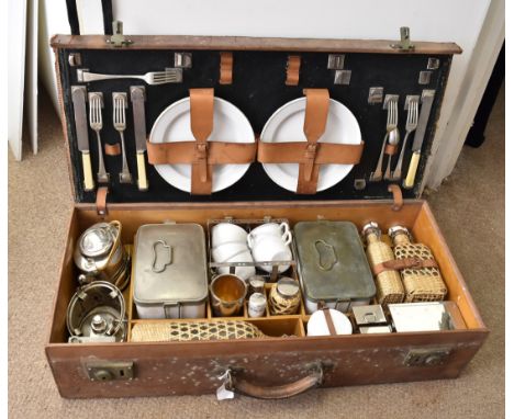 An Art Deco leather and wood-lined motor car picnic hamper, with china plates, enamel cups, silver plated graduated beakers, 