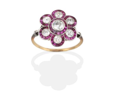 An Early Twentieth Century Ruby and Diamond Cluster Ring, a central old cut diamond within a flower head border of grain set 
