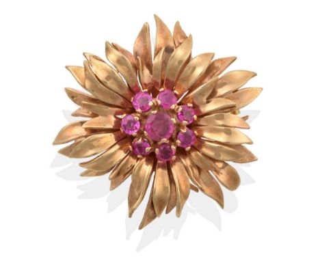 A Ruby Floral Brooch, a cluster of round cut rubies within a petal surround, measures 3.5cm in diameter see illustration  .  