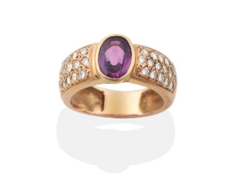 A Ruby and Diamond Ring, an oval cut ruby in a rubbed over setting, to a broad shank pavé set with round brilliant cut diamon