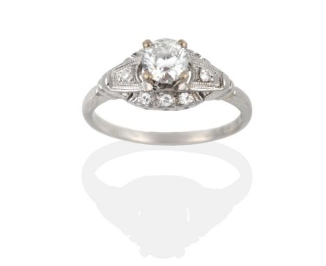 An Early Twentieth Century Solitaire Diamond Ring, a round brilliant cut diamond in a claw setting, above a grain set diamond