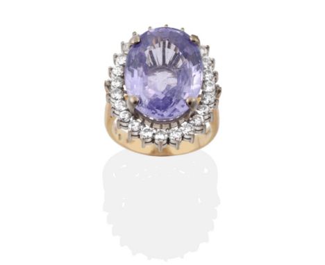 A Violet Sapphire and Diamond Cluster Ring, an oval cut violet sapphire within a border of round brilliant cut diamonds, to t