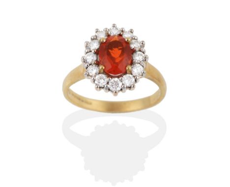 An 18 Carat Gold Fire Opal and Diamond Cluster Ring, an oval cut fire opal within a border of round brilliant cut diamonds, t