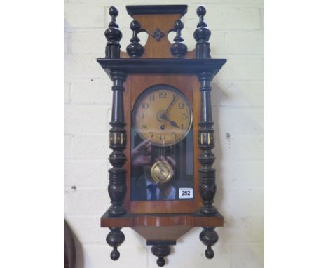 An early 20th century walnut Vienna style wall clock having aged dial with Arabic numerals and minute track, gilt centre piec