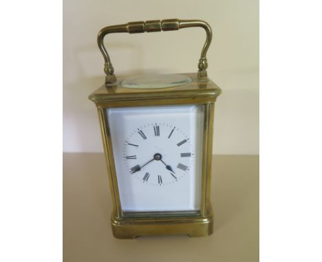 An early 20th century French brass Richard & Cie Carriage clock with four bevelled glass panels, enamel dial with Roman numer