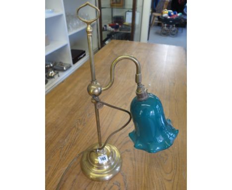 A brass lamp with a green shade 