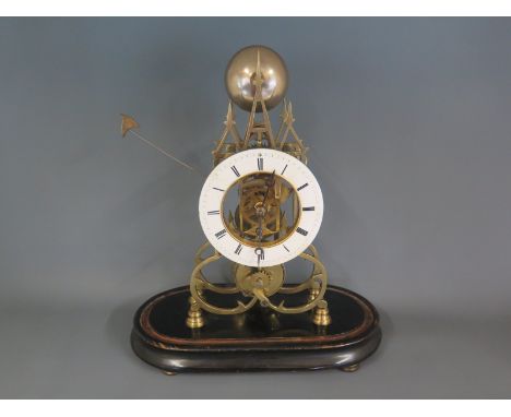 A late 19th century brass Skeleton clock in the Gothic style with fusee movement and separate chapter ring, beneath a glass d