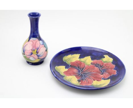 A Moorcroft charger on blue background with a similar vase (2), 22cm diameter.  In good condition with no obvious damage or r