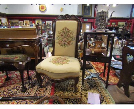 A circa 1840 rosewood open armchair with carved decoration and tapestry upholstery on cabriole legs and castors