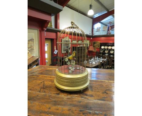 A late 19th Century early 20th Century automaton yellow singing bird with branch and foliage
