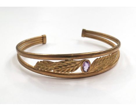 A 9ct gold bangle with leaf form centre and pink citrine stone, 6.9g total 