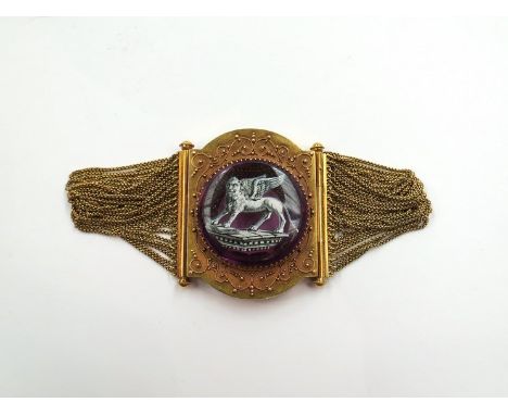 A gold bracelet with amethyst coloured glass circular panel painted with an image of The Lion of Saint Mark, Venice in an orn