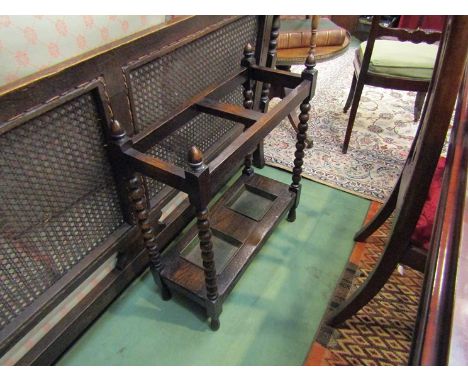 A circa 1910 oak two division stick/umbrella stand with turned acorn finial's on bobbin turned supports joined by an undertie