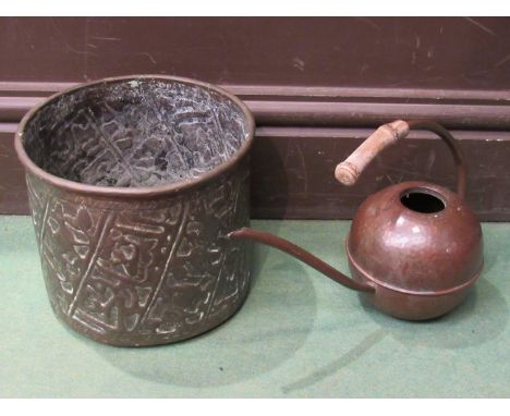 A bygone copper watering can and a brass planter 