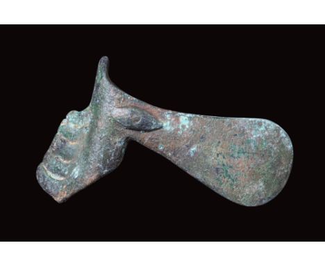Ca. 2nd - 1st millennium BC.A bronze ceremonial axe head with a stylised animal-like form transitioning into a blade-like ext