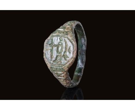 Ca. AD 900 - 1000.A bronze ring with a flat-section hoop widening to form a bezel engraved with a depiction of a left-facing 