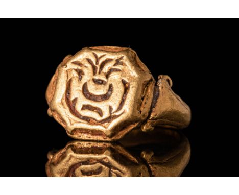 Ca. AD 600 - 1200.A 21 ct gold finger ring with an octagonal bezel and a round hoop. The shoulders are decorated with volutes