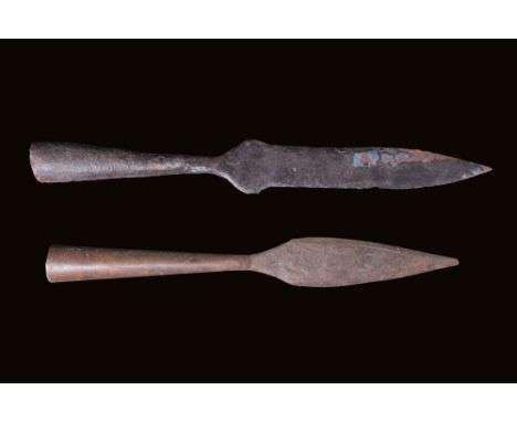 Ca. AD 800 - 1400.A pair of iron socketed spearheads. Each spearhead has a tubular hollow shaft flaring gradually towards the