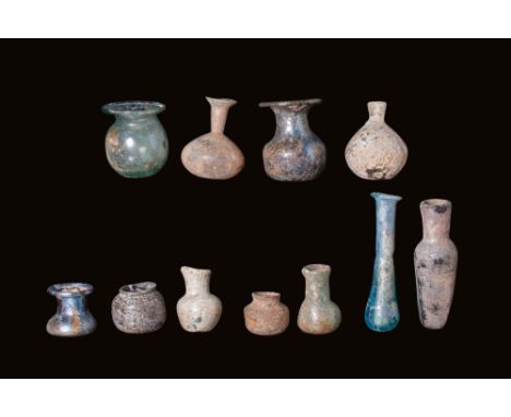 Ca. AD 1 - 400.A group comprising 11 glass containers, displaying various shapes and styles. Among them are bulbous flasks, b