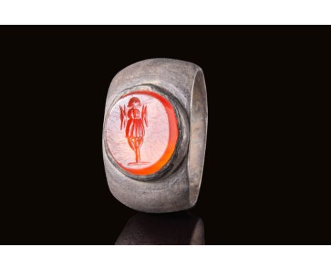 Ca. AD 1 -100.A carnelian intaglio, intricately carved to depict a war trophy - a display of captured enemy weapons and armou