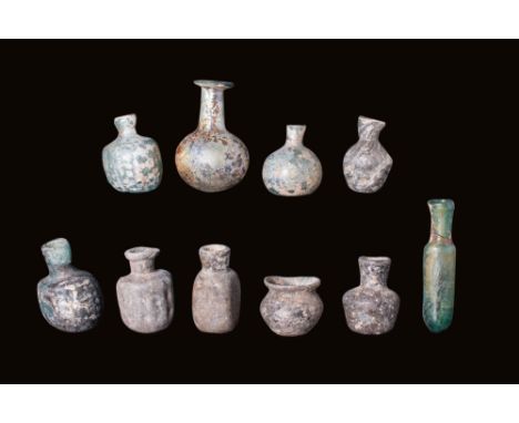 Ca. AD 1 - 400.A group comprising 10 glass containers, displaying various shapes and styles. Among them are bulbous flasks, b